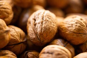 Detailed close-up image of walnuts in shell, showing texture and natural color.